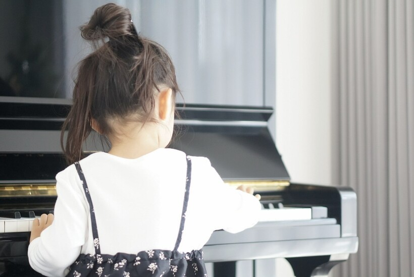 子供がピアノを弾いている後ろ姿
